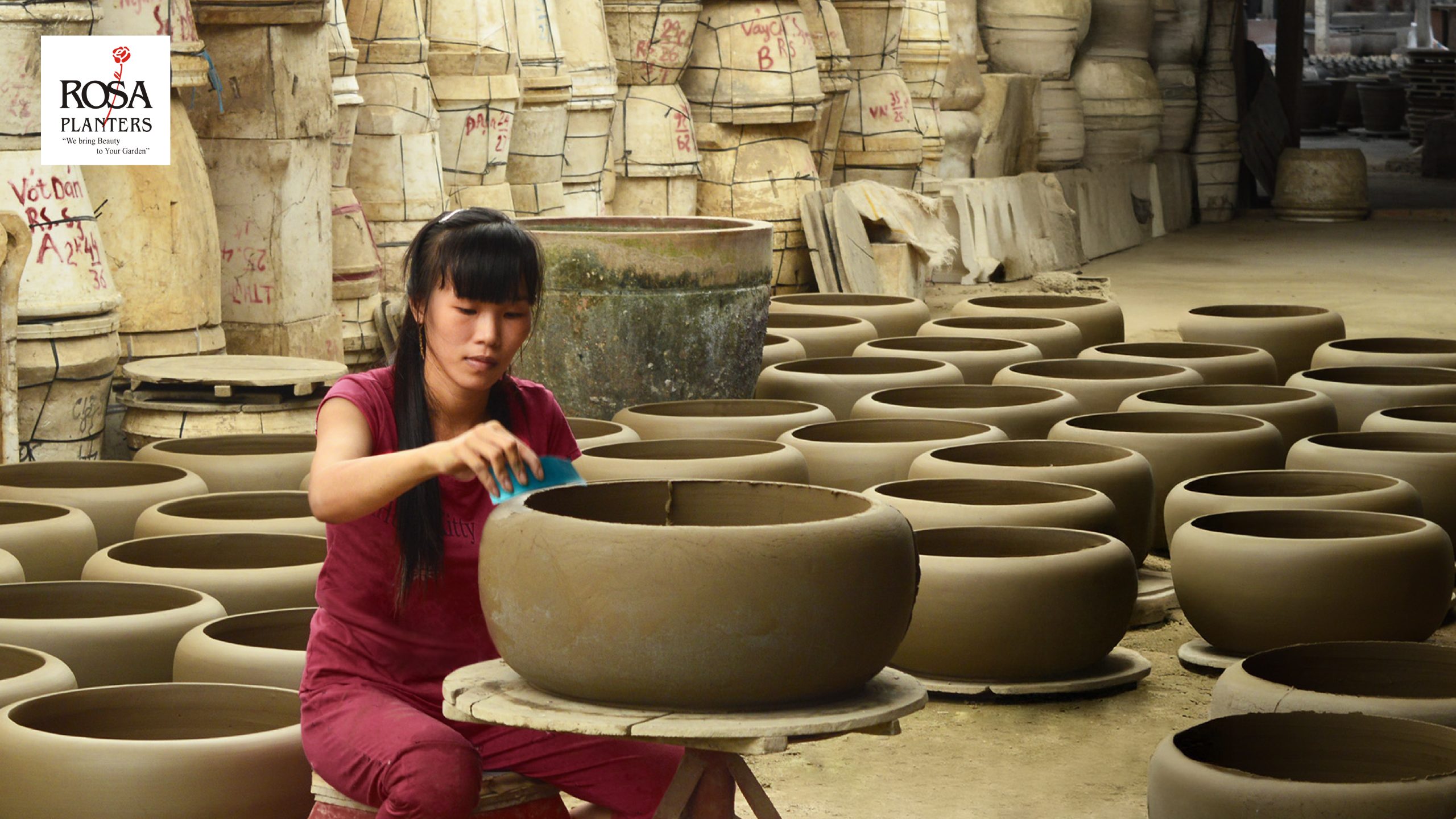 Vietnamese pottery artisans handcrafting ceramic plant pots in a pottery workshop