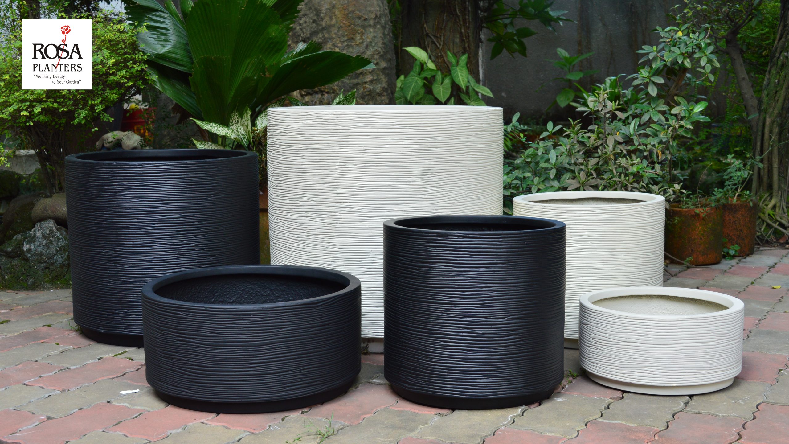 Collection of polystone planters in assorted shapes and sizes displayed together
