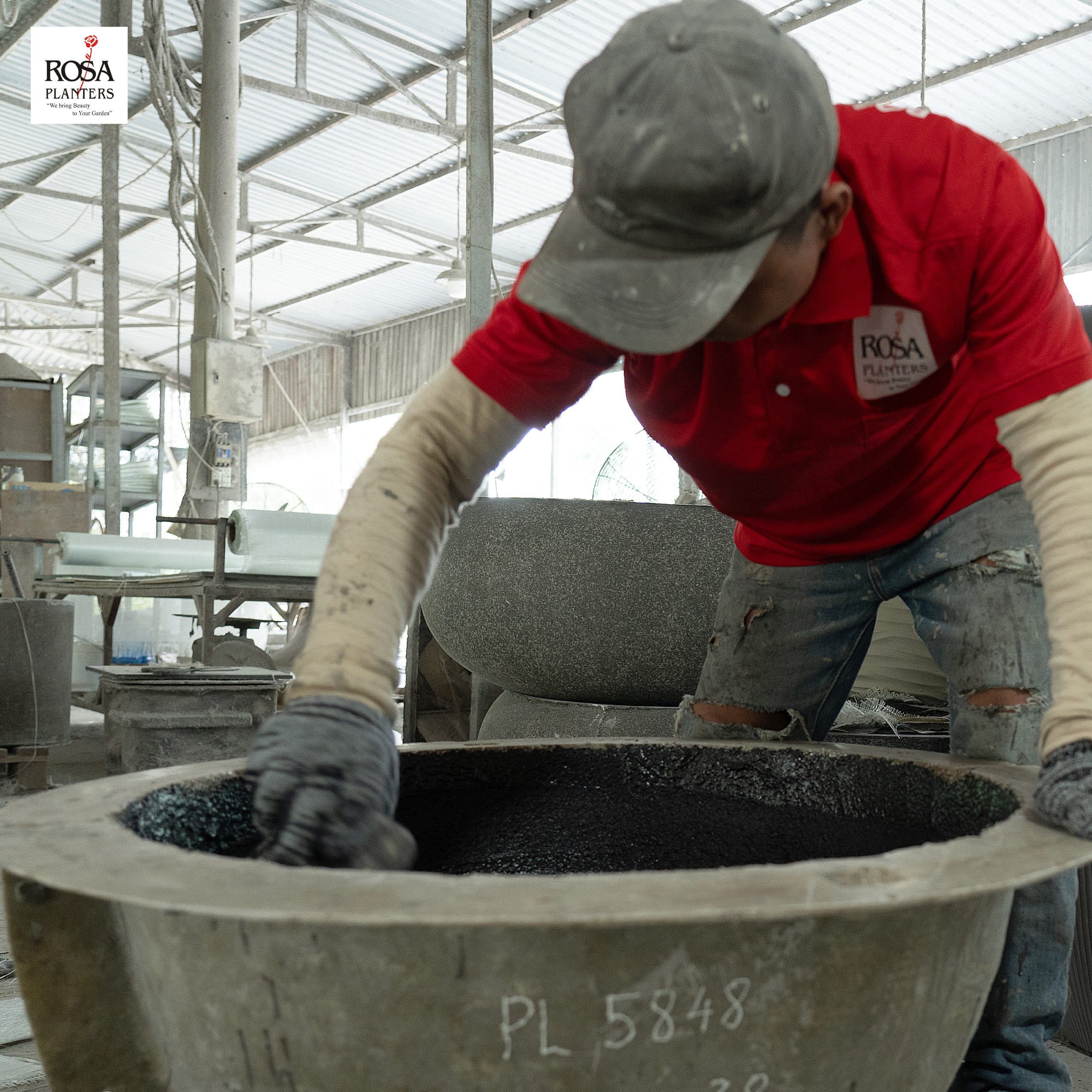 Worker making a polystone planter by hand in layers